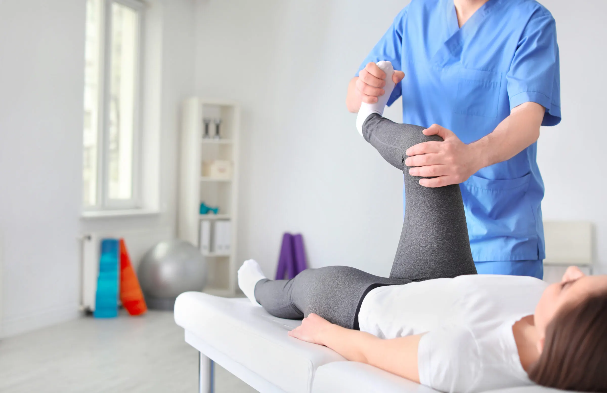 Fisioterapia en Bilbao y Mungia: fisioterapeuta trabajando con una paciente en la camilla de la clínica