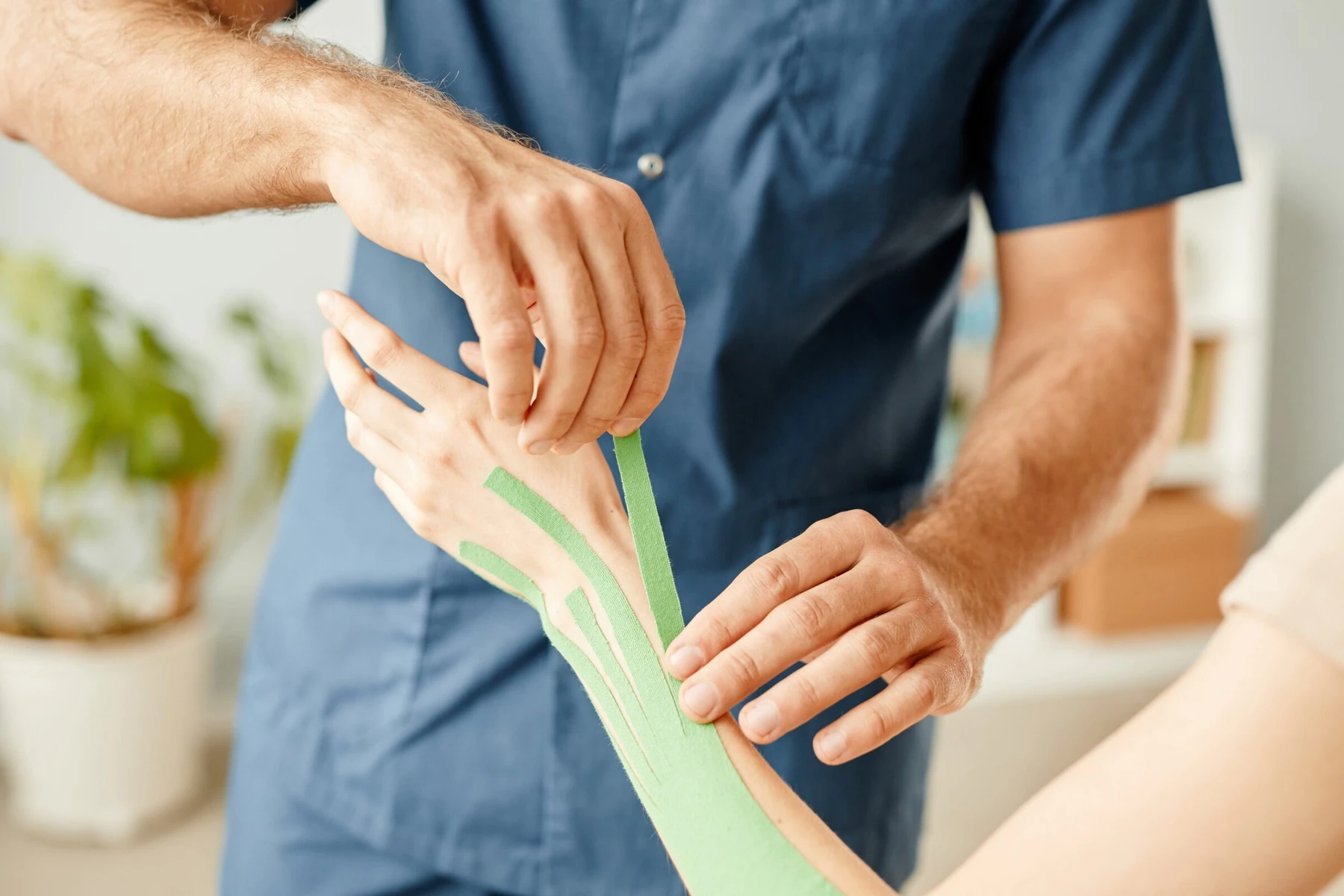 Fisioterapia en Bilbao y Mungia: aplicación de vendaje neuromuscular en el brazo de un paciente