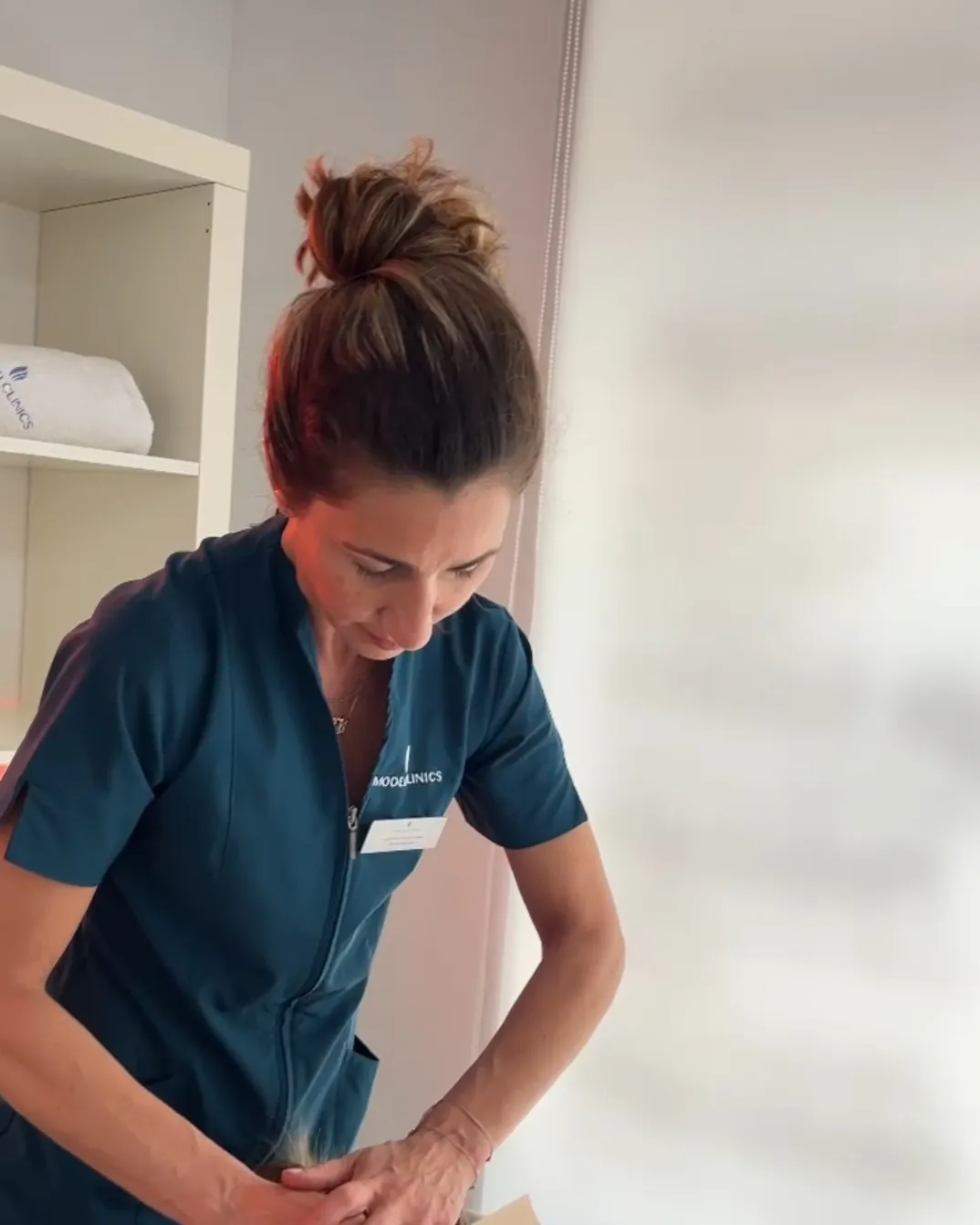 Fisioterapeuta de Clínica Malai tratando a un paciente en camilla durante una sesión de fisioterapia